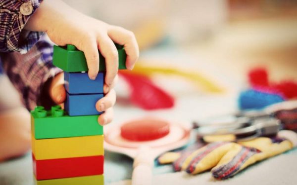 Child plays building a tower with bricks